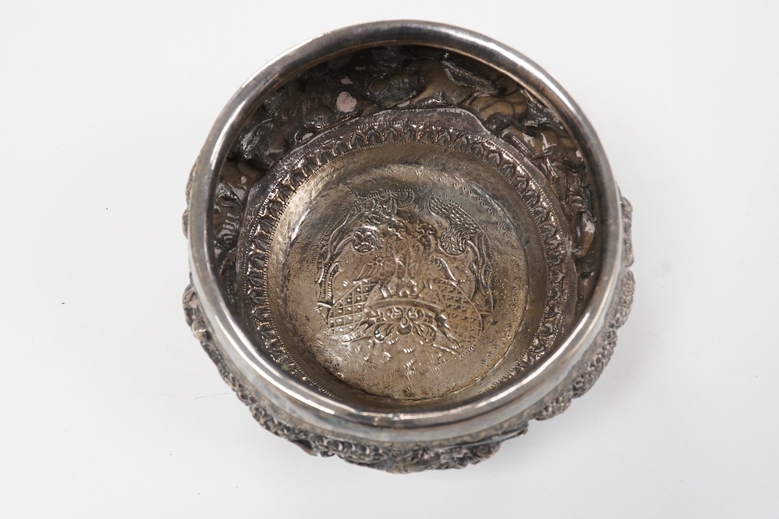 A late 19th/early 20th century Burmese white metal bowl, embossed with figures and animals in continuous battle scene, top diameter 12.4cm.